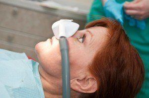 Lady wearing sedation nosepiece, getting laughing gas as a option for sedation dentistry.